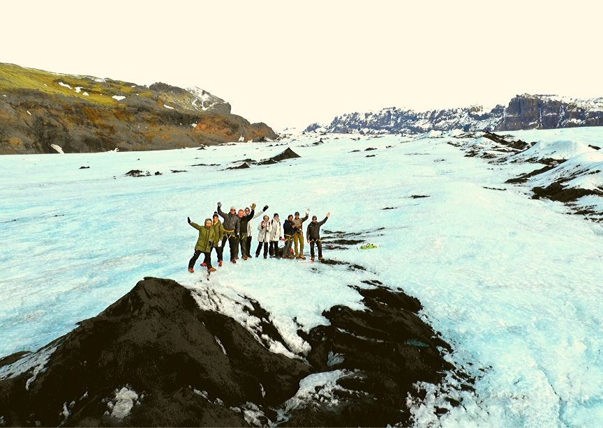 Iceland group winter tour waving from glacier hike