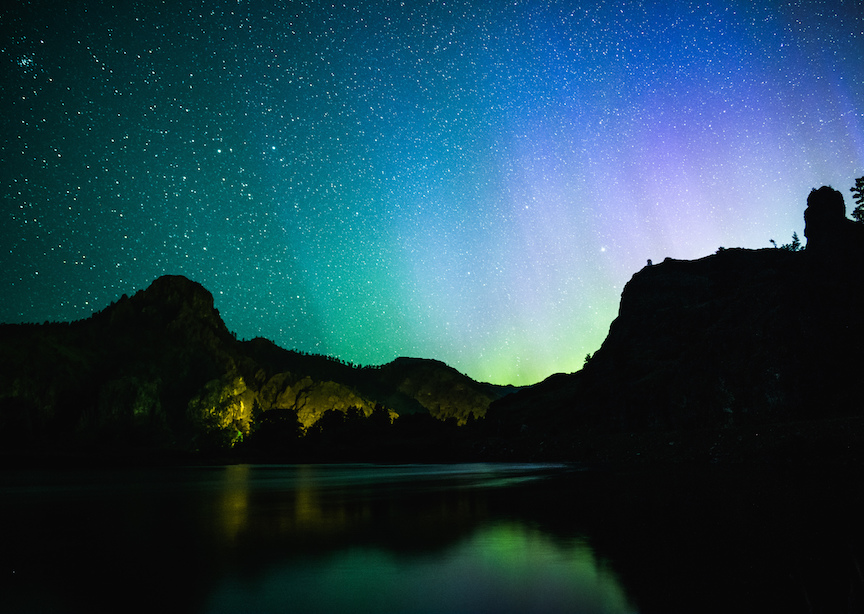 Montana mountains and lakes with northern lights in starry skies